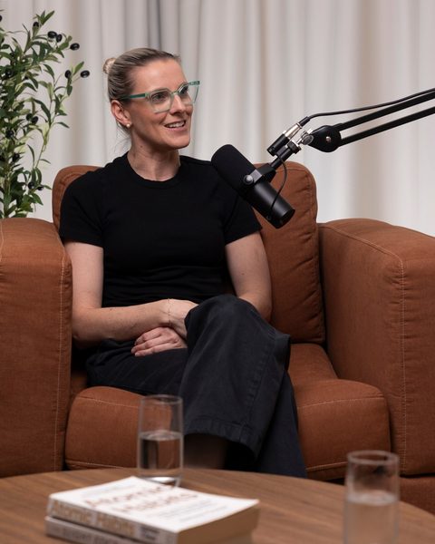 Tash Miller laughing on the couch during a podcast recording