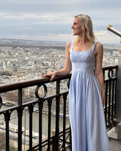 Tash Miller in a blue dress at the top of the Eiffel Tower